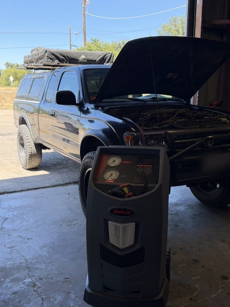 Air conditioning recovery machine connected to a pickup during A/C service at NorCal Precision Auto in Redding, CA