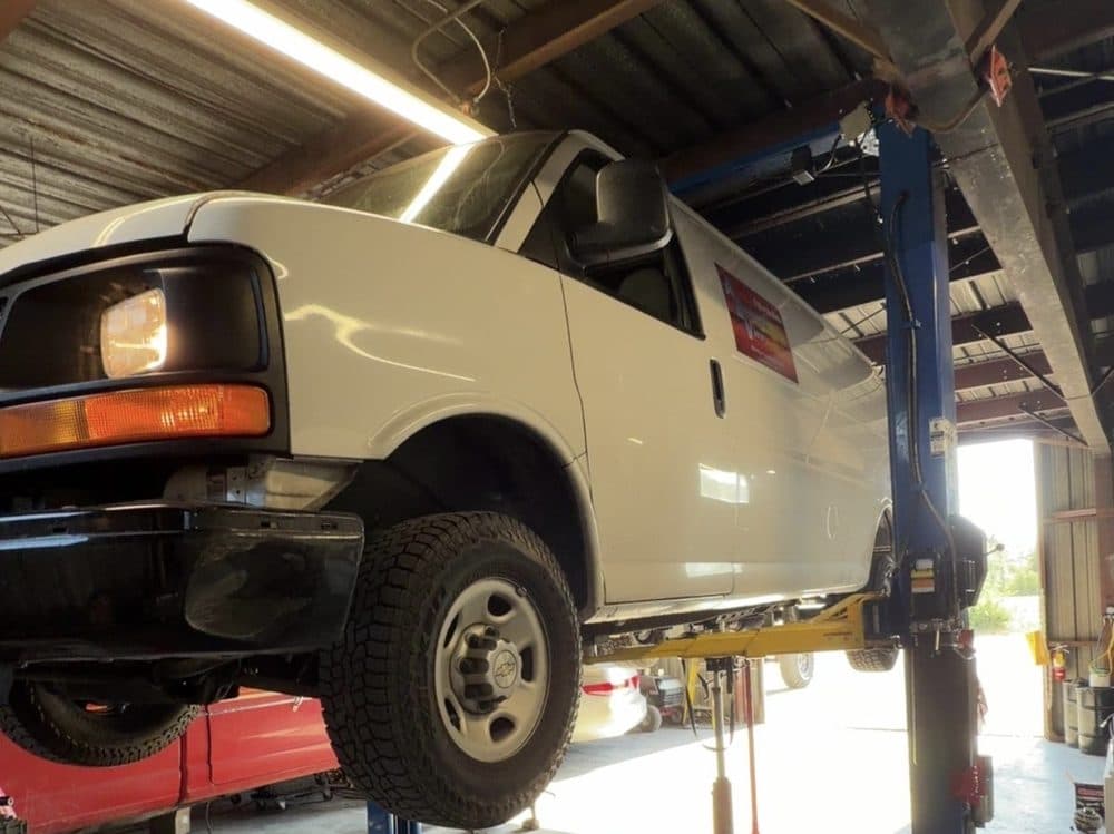 Cargo van raised on the lift for undercarriage work at NorCal Precision Auto in Redding, CA