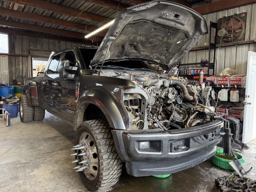 Ford Super Duty dually with the front end apart and the diesel engine exposed at NorCal Precision Auto in Redding, CA