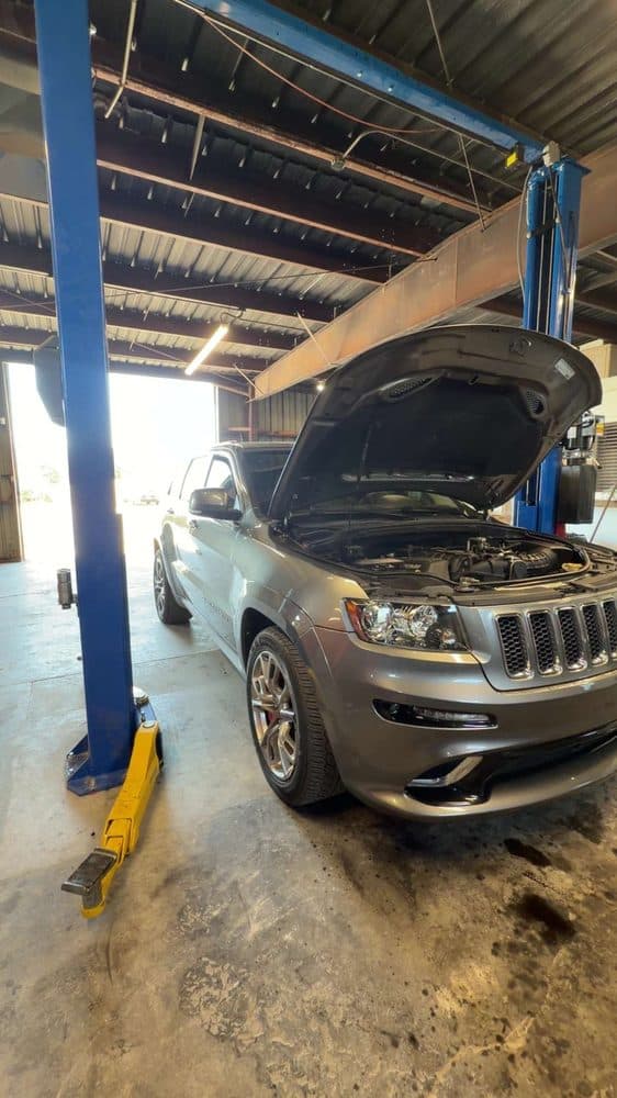 Jeep Grand Cherokee on the lift with the hood open at NorCal Precision Auto in Redding, CA